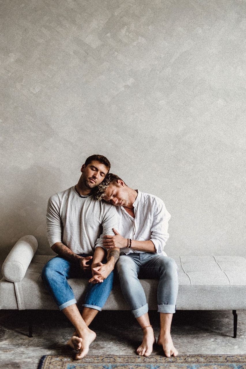 Michael und Tim Overdick sitzen auf einer Couch und kuscheln.